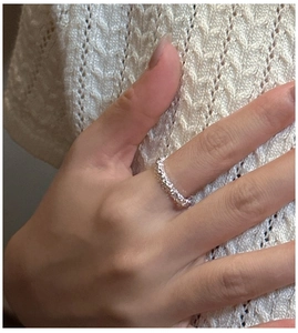 Macro shot of S925 sterling silver ring with textured surface on model's finger