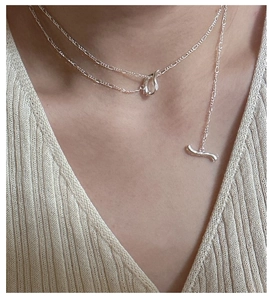 Close-up of S925 sterling silver OT toggle necklace on a beige knit sweater model