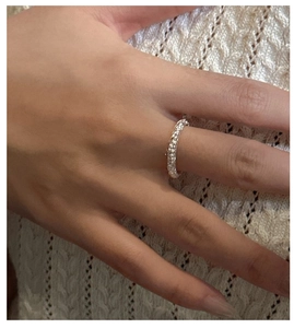 Detail of S925 sterling silver ring with textured braided design on a hand