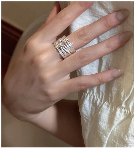 Detail shot of a wide multi-layered silver ring with unique intertwined line design