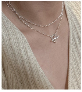 Close-up of S925 sterling silver layered necklace featuring a vintage OT toggle clasp