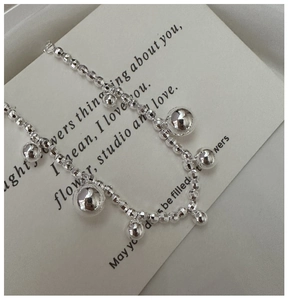 Macro detail of S925 sterling silver laser beaded bracelet with polished silver pendants