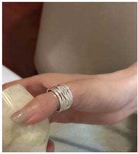 Macro detail of S925 sterling silver multilayer woven wide ring on model finger