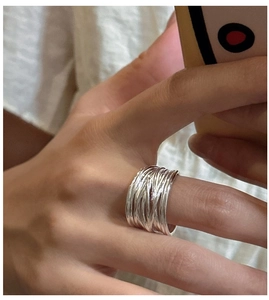 Macro detail of polished wide multi-layer silver ring on hand with minimalist aesthetic