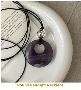 Macro detail of natural purple amethyst donut pendant with silver beads and black cord