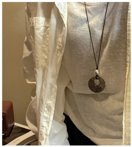 Détail du collier avec pendentif en pierre naturelle et perle d'argent sur cordon noir