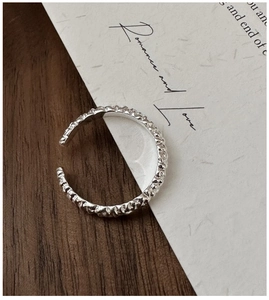 Macro detail of silver ring with irregular hammered texture on adjustable band