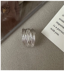 Macro detail of the silver woven nest design and layered wire texture on the wide ring