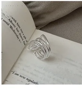 Nahaufnahme eines mehrlagigen S925 Silberrings auf einem Buch für minimalistischen Stil