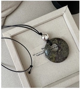 Détail du collier avec pendentif en pierre naturelle verte, perle argent et cordon noir