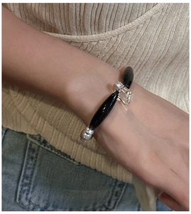 Dettaglio del bracciale in argento S925 con perle di agata nera e distanziatori in metallo al polso