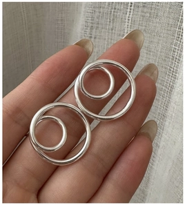 Close-up of minimalist S925 sterling silver hollow double hoop spiral stud earrings