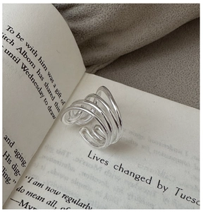 Nahaufnahme eines silbernen mehrschichtigen Rings auf einem Buch bei sanftem Licht