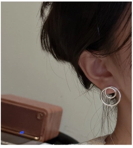 Detail view of S925 sterling silver hollow double ring earrings worn on ear