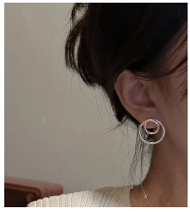 Detail of S925 sterling silver interlocking hollow hoop earrings worn by a model