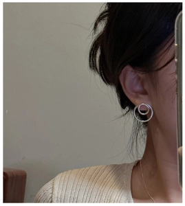 Detail of S925 sterling silver interlocking double hoop earrings on model ear