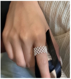 Detail of vintage silver mesh ring with beaded edges worn on index finger