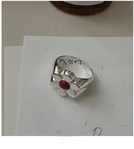 Detailed macro view of S925 silver flower ring with a deep red natural stone inlay