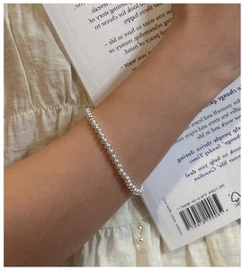 Detailed close-up of polished S925 sterling silver beaded bracelet on wrist