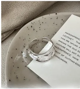 Detailed view of an S925 sterling silver irregular texture ring on a ceramic display