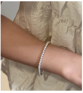 Macro view of polished silver bead chain bracelet on wrist showing minimalist aesthetic