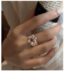 Detail of S925 silver ring featuring a red stone center in a floral motif pattern