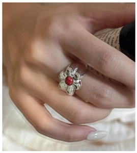 Detailed close-up of S925 silver flower ring featuring a vibrant round red gemstone
