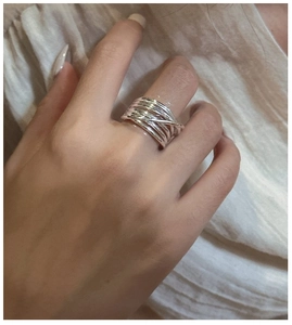 Close-up of S925 sterling silver multi-layer overlapping wire ring on a model's finger