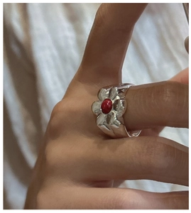 Detail of vintage S925 silver ring featuring floral design with a red gemstone inlay