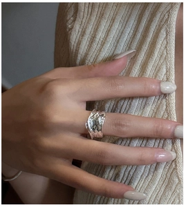 Detail of S925 sterling silver ring with irregular lava texture on model finger