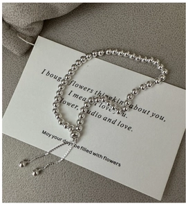 Macro detail of adjustable S925 sterling silver beaded bracelet with high-polish finish