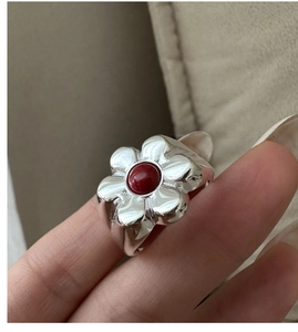 Detailed view of an S925 silver floral ring with a central round red natural stone