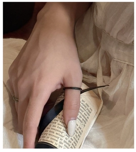Gros plan d'une bague de pouce minimaliste en bronze mat sur fond de lin esthétique