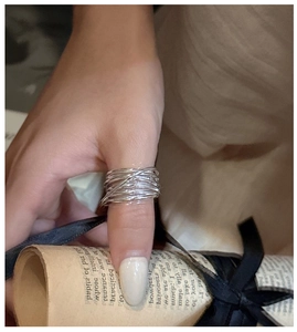 Detail of multi-layer crisscross silver line ring showing its artistic layered texture