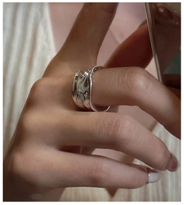 Detailed view of an irregular molten silver ring with polished textured liquid metal surface