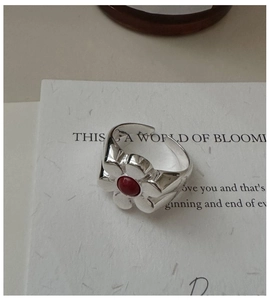 Macro shot of a retro S925 silver ring featuring a red gemstone in a five-petal flower
