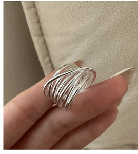 Detail of S925 sterling silver multi-layer crisscross ring worn on a finger