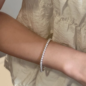 Minimalist S925 sterling silver beaded bracelet on model wrist with metallic sheen