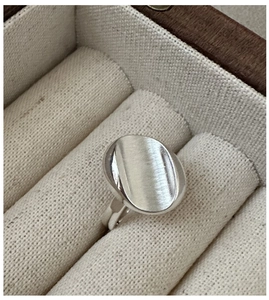 Macro shot of minimalist S925 sterling silver ring with brushed oval surface texture