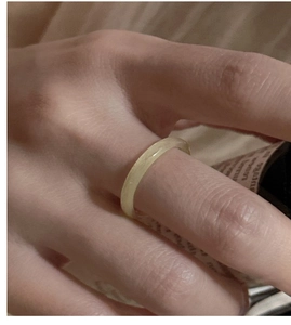 Vue détaillée d'une bague en calcédoine beige minimaliste portée à la main lise