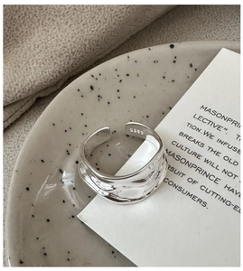 Detailed close-up of S925 sterling silver open ring with irregular wave texture
