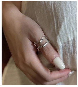 Close-up of a double-layered V-shaped sterling silver ring on a model's hand