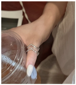 Close-up of a double-layered wavy S925 sterling silver ring worn on the thumb