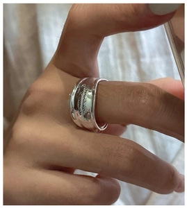 Detailed view of wide S925 sterling silver ring with engraved cursive letters on finger