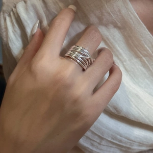 Minimalist S925 sterling silver multilayer crossover ring on model hand with soft light