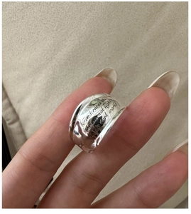 Detail of wide S925 silver ring with engraved quote and irregular wavy edges