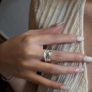 Minimalist S925 sterling silver ring with irregular liquid texture on model's finger