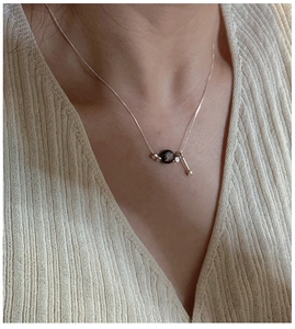 Detailed view of S925 sterling silver water drop necklace with rose gold chain and black bead