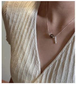 Detail of S925 sterling silver teardrop necklace on model with vintage bead pendant
