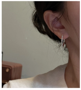Gros plan de boucles d'oreilles créoles perlées en argent sterling au style minimaliste